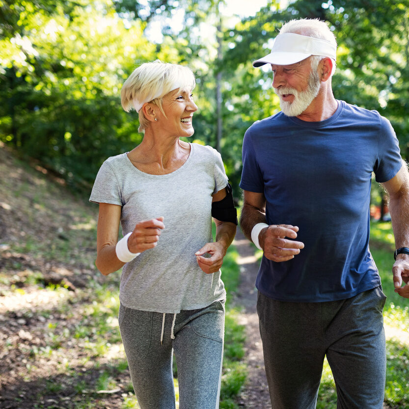 Senior couple jogging and running outdoors in nature